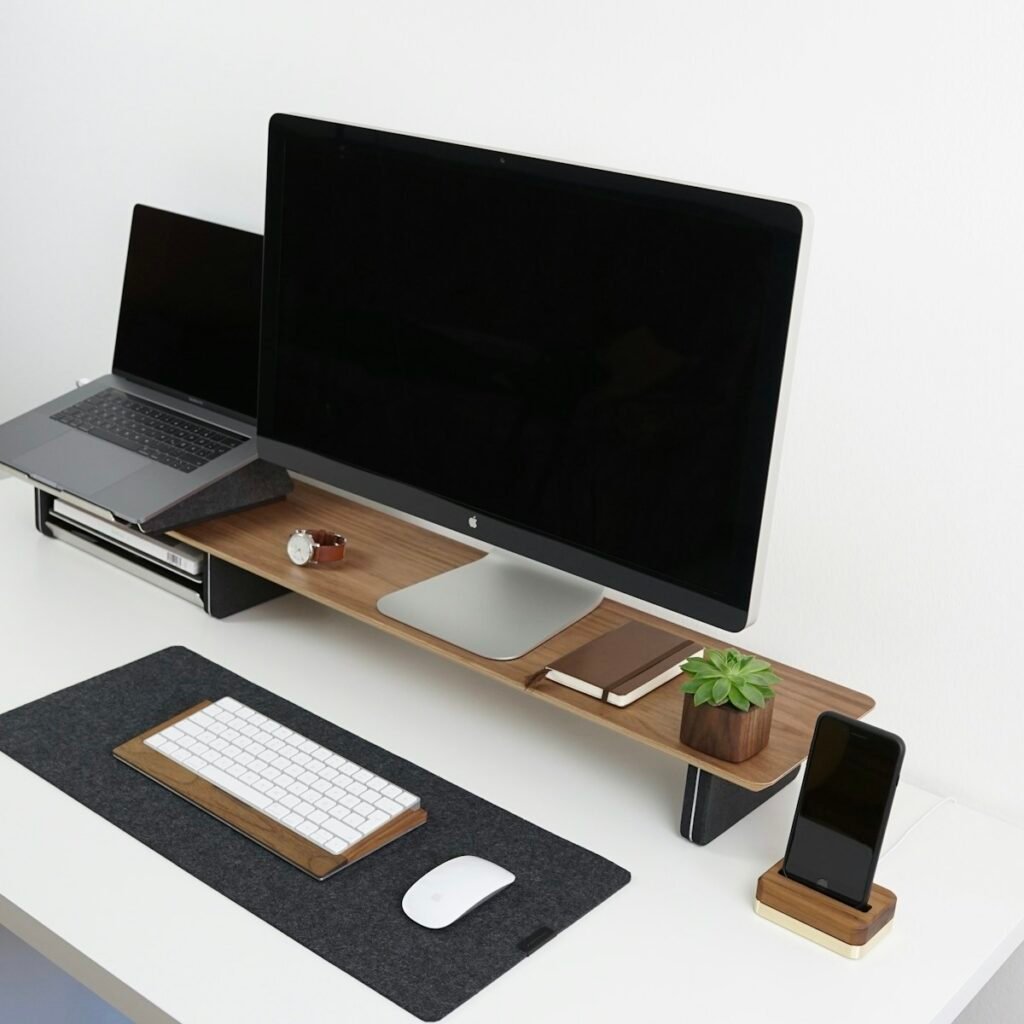 Walnut monitor stand on a desk with felt mat